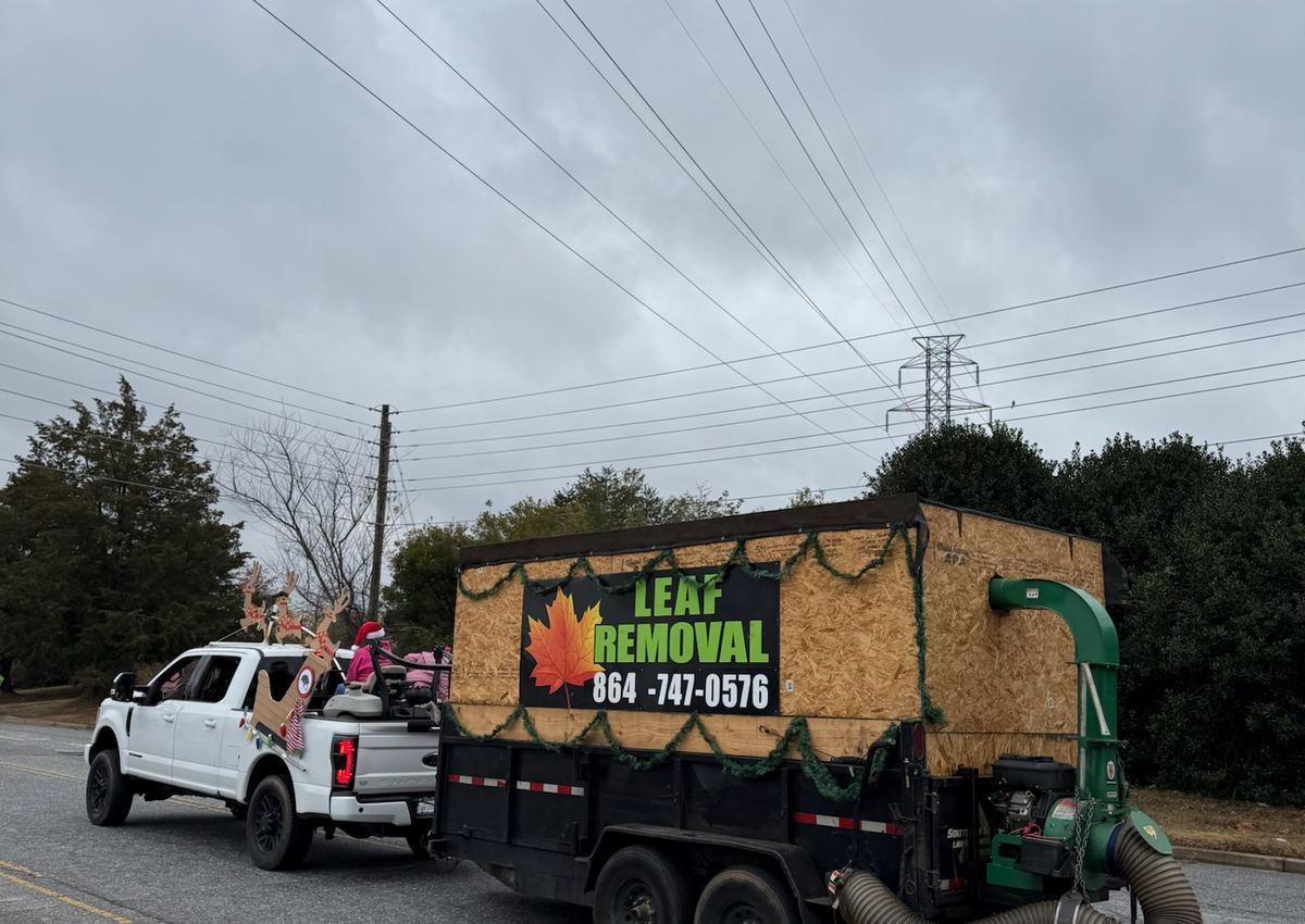 The company leaf vacuum truck parked on a residential street during a seasonal cleanup.