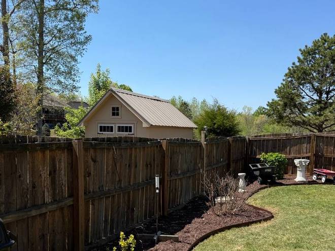 A freshly mulched bed following the curve of a lawn edge.