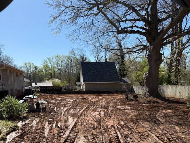 Freshly graded ground worked to shape behind a house.