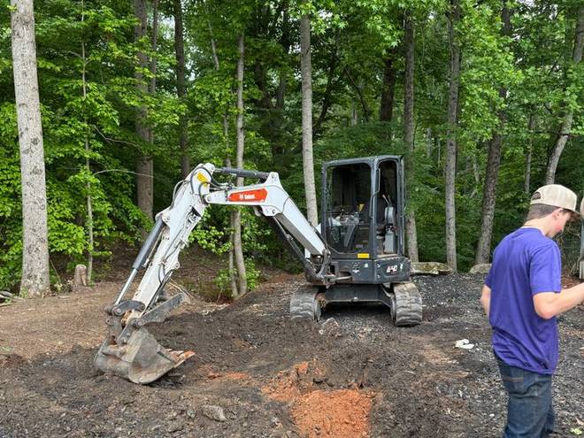 A mini excavator working soil on a residential job.