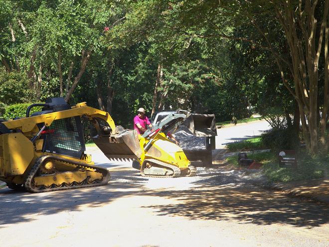 The loader operator moving material near the street.