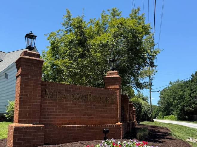 Brick entrance columns with an annual flower bed at the base.