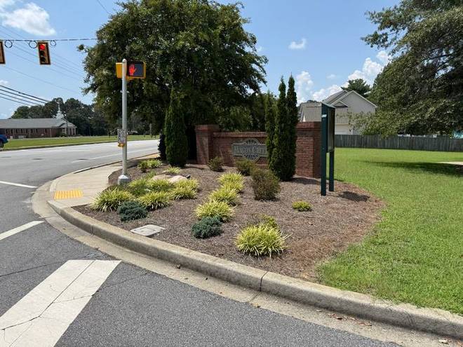 A planted entrance island on a corner, kept on a weekly schedule.