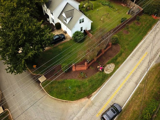 Aerial view of a subdivision entrance and its turf beside the road.