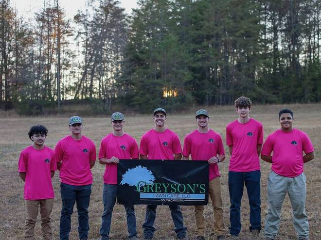 The crew lined up together in matching fuchsia shirts.