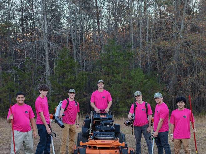 The crew standing with their commercial mowers.