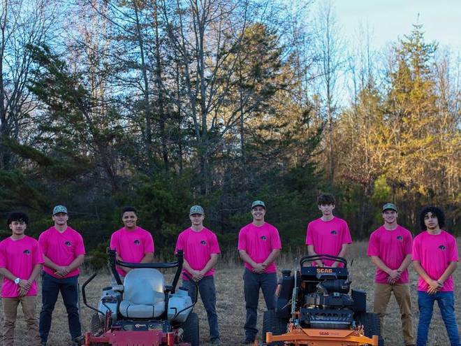 The full crew with their mowers at the end of a working day.