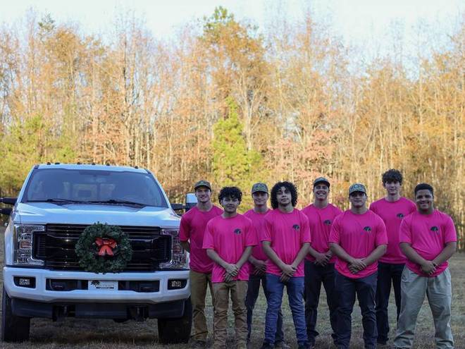 The crew lined up in front of a company truck.