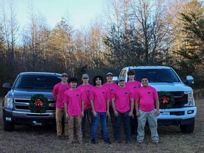 The crew photographed together with the company trucks.