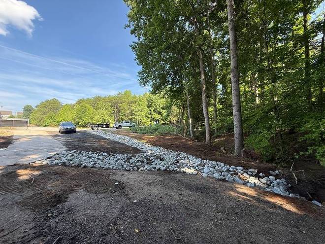 A gravel drainage run installed along the side of a property.