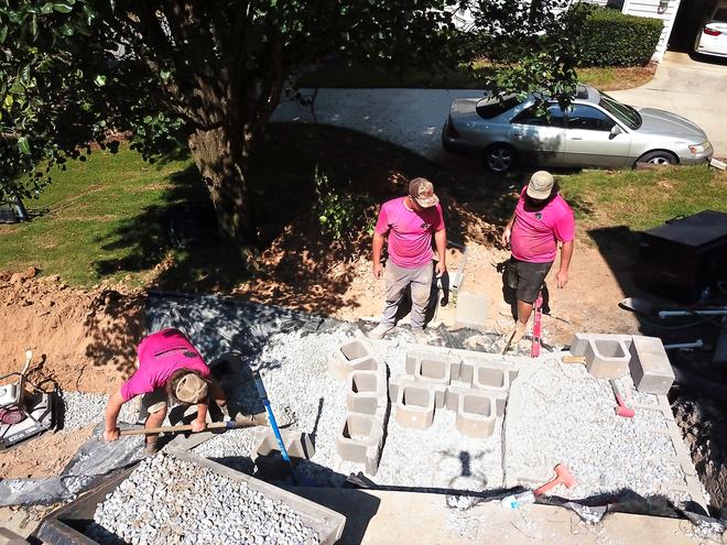 Overhead view of the crew laying the first course of a block retaining wall.