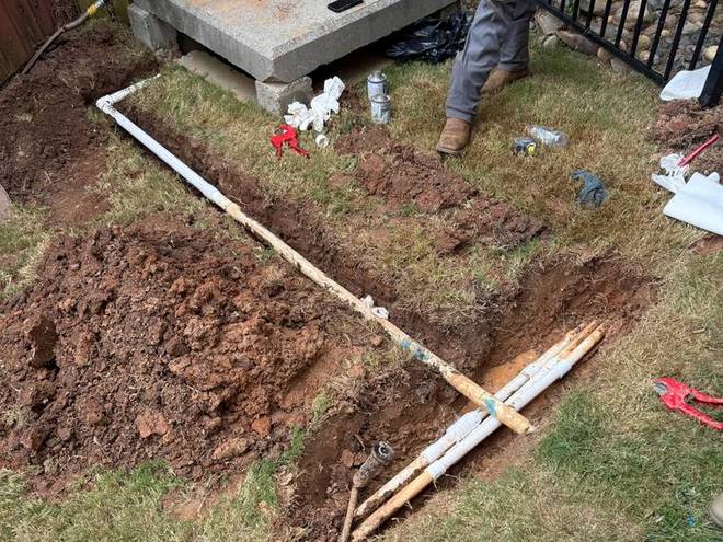 An irrigation valve box being set into the ground during installation.