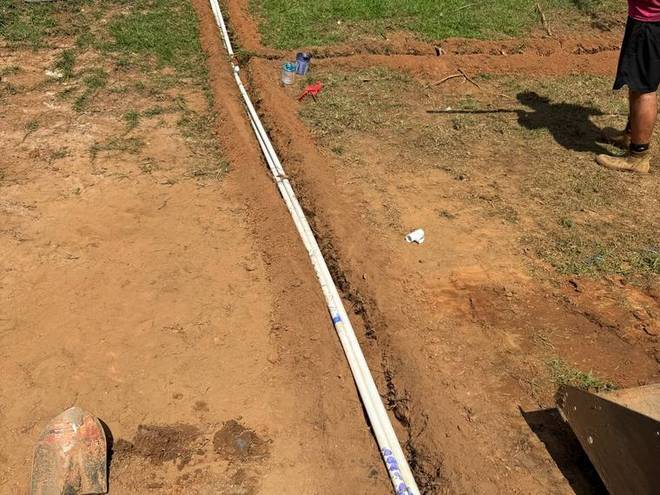 An irrigation trench running along a boundary during installation.