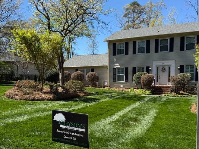 A maintained front lawn with a clean edge along the driveway.