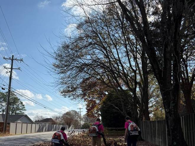 Crew clearing leaves from a property at the end of the day.