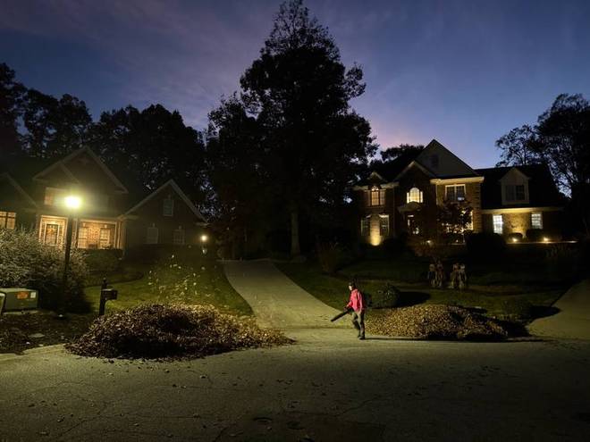 A home and its landscaping lit at dusk by landscape lighting.