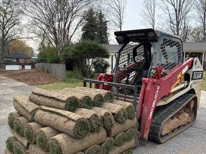 Pallets of fresh sod loaded on a track loader ready to be laid.