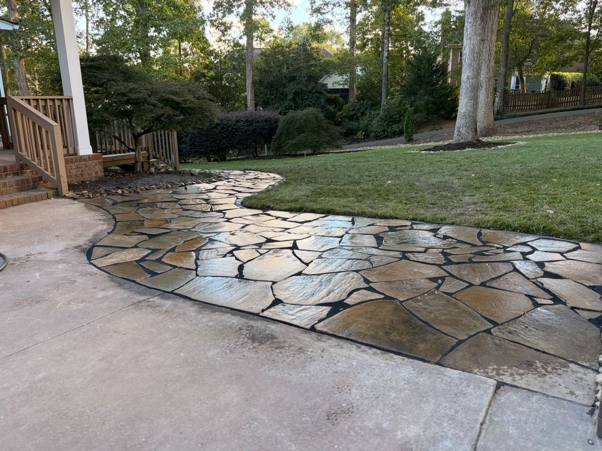 A finished flagstone patio and walkway laid into a back lawn.