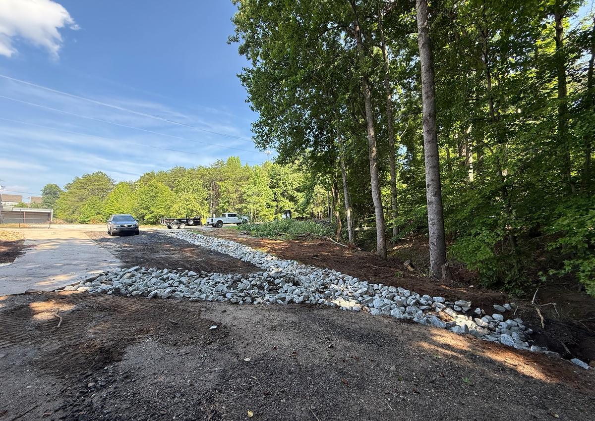 A gravel drainage run installed along the side of a property.