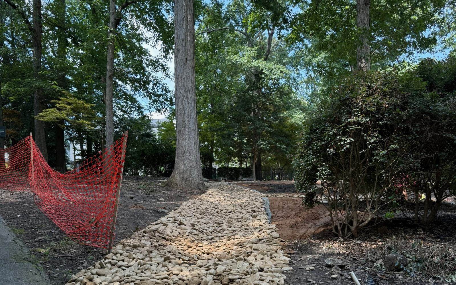A dry creek bed of river rock built to carry water away from a home.