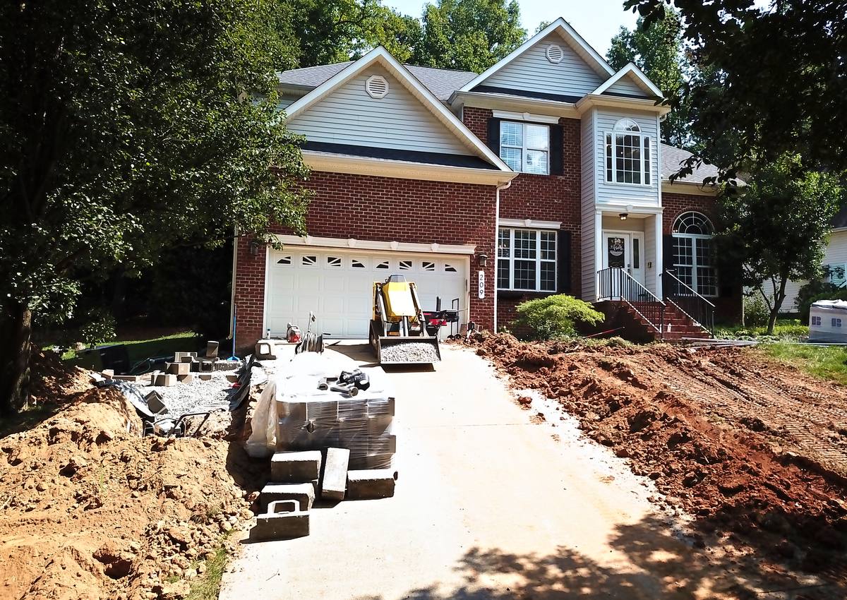A drainage trench excavated through a front yard, seen from above.
