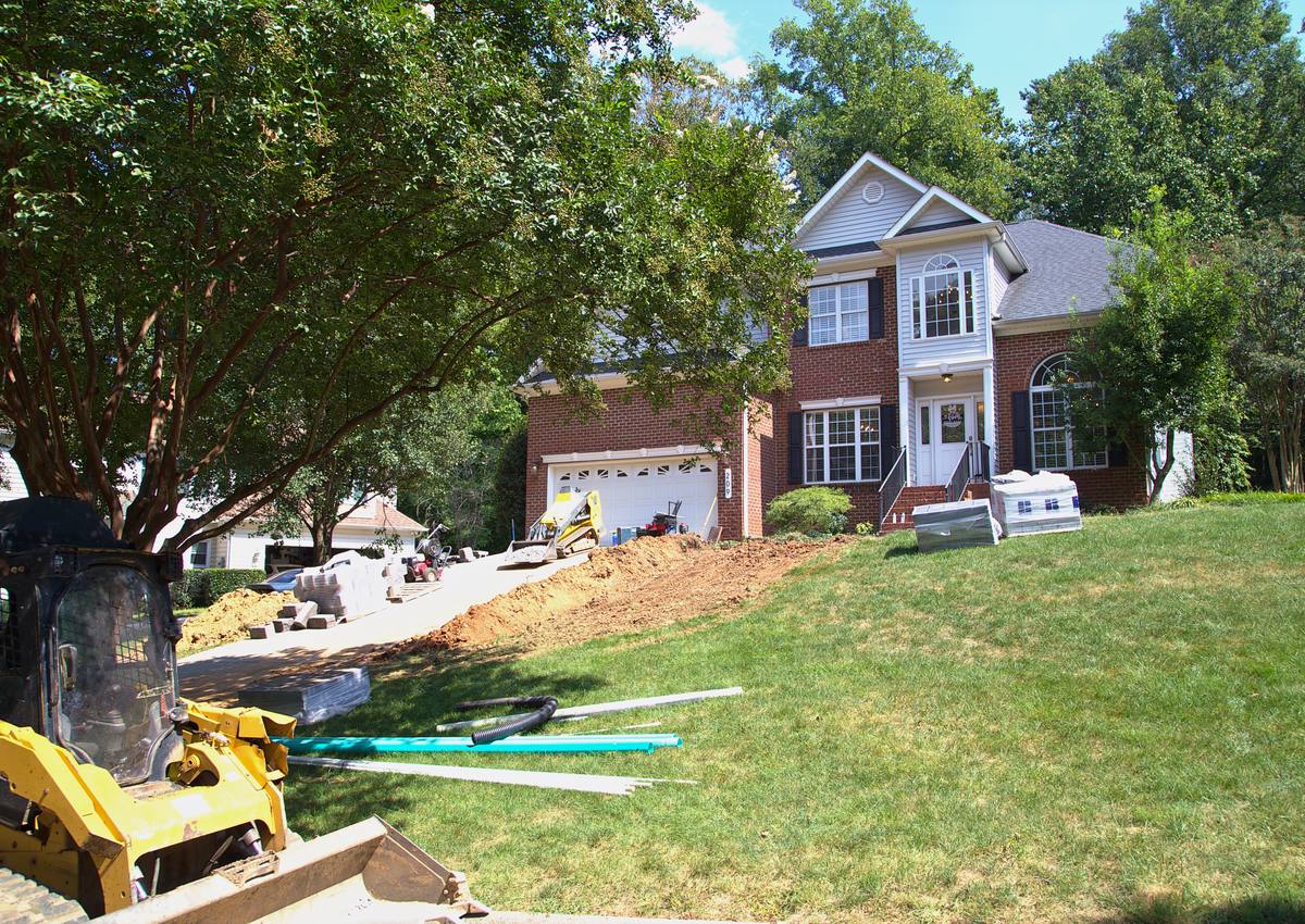 Drainage pipe laid out across the lawn ahead of trenching.