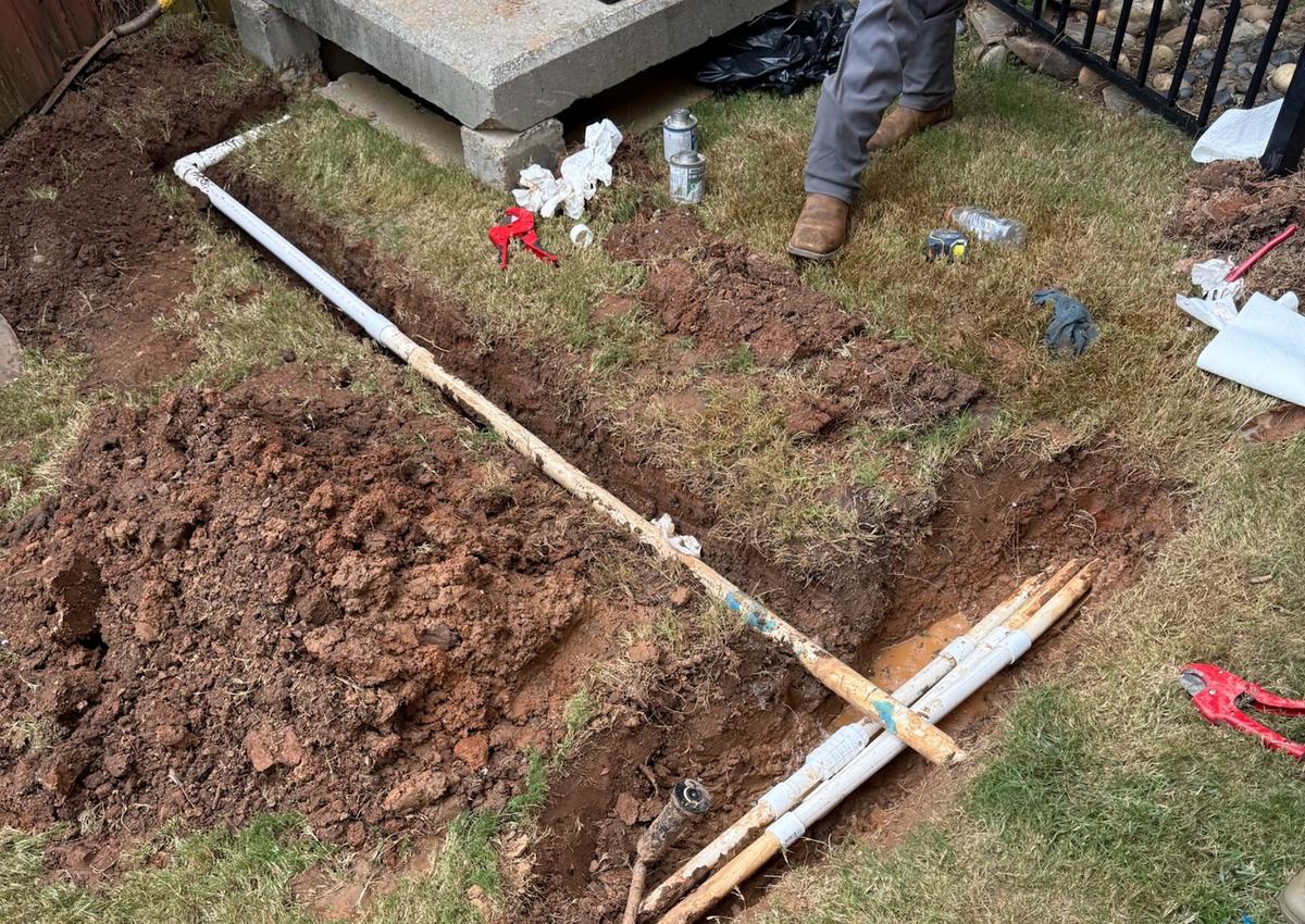 An irrigation valve box being set into the ground during installation.