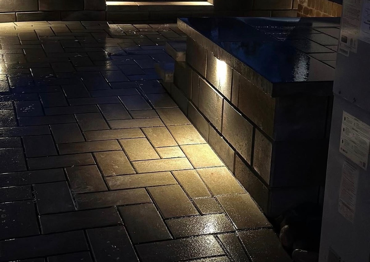 Step and wall lighting picking out the level changes on a patio at night.