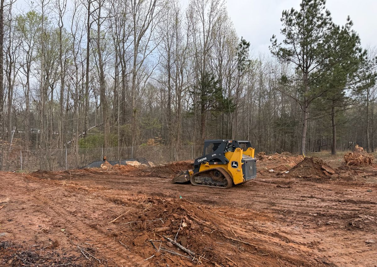 A cleared and graded lot with a track loader working the dirt.