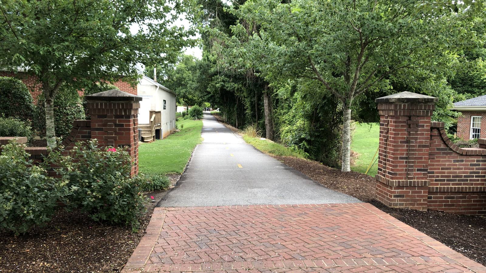 A brick entrance and paved section of the Swamp Rabbit Trail in Travelers Rest, South Carolina.